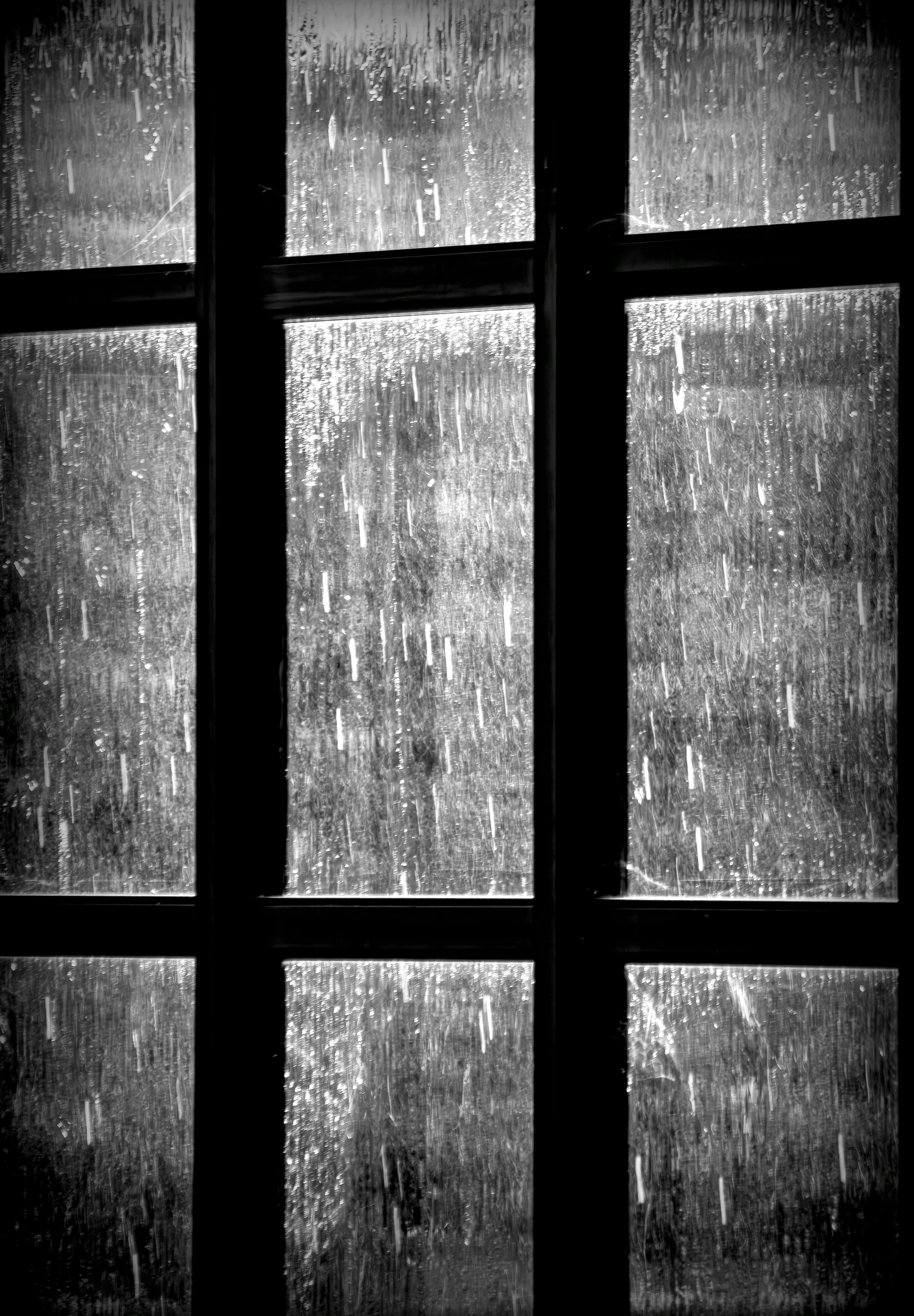 Rain streaking a dark window, representing isolation and uncertainty